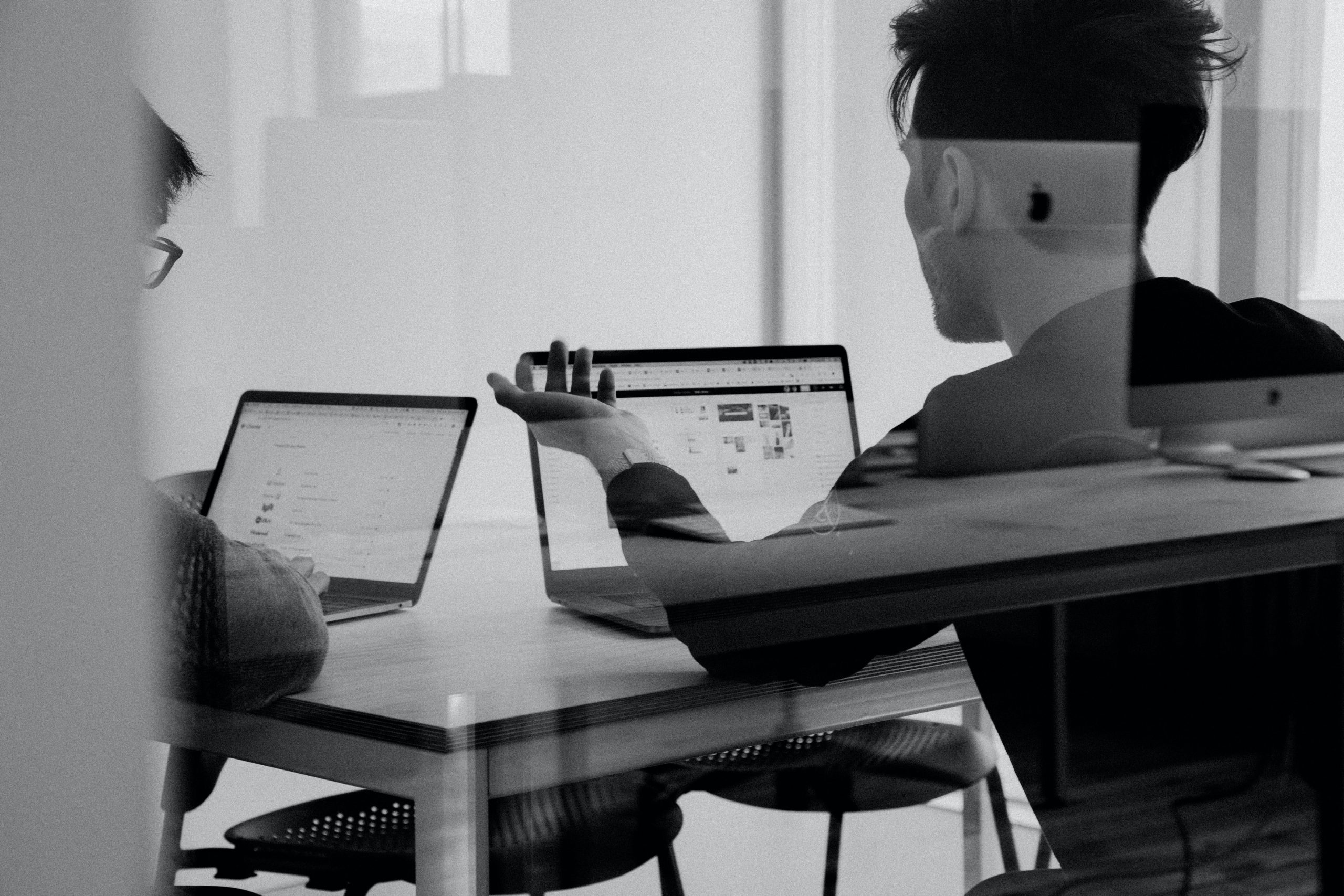 black and white photo of 2 people working in office